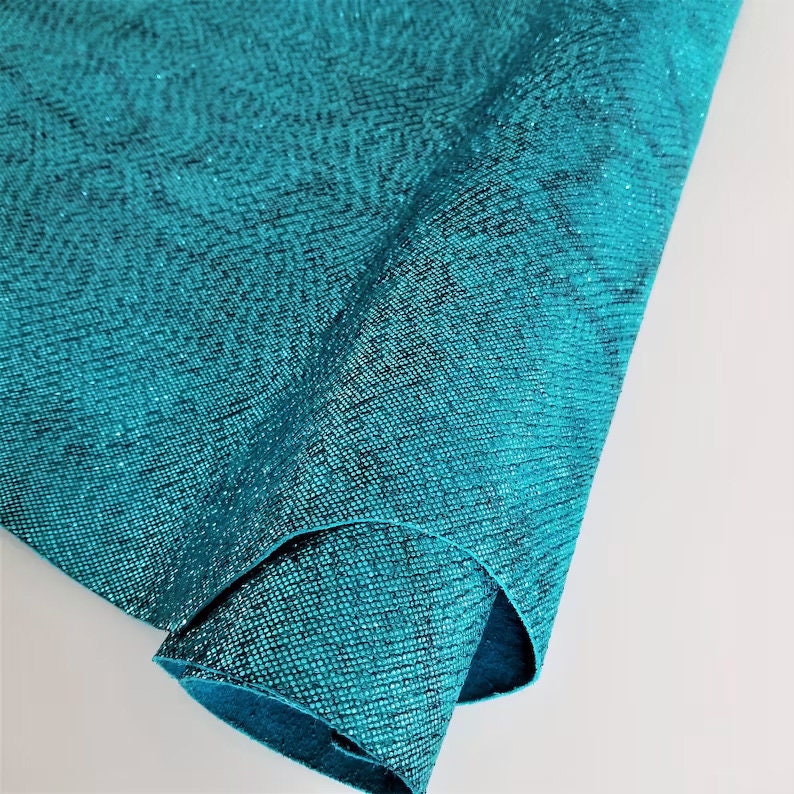 Close-up of teal textured fabric on a light gray background