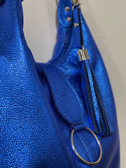 close up of pebble Blue leather handbag with a tassel and ring detail.