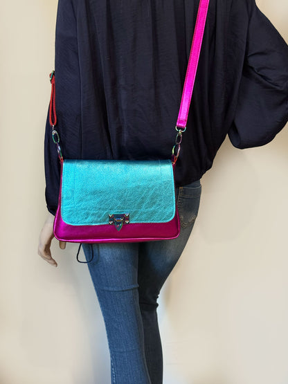 full length Person wearing a blue and pink metallic leather handbag crossbody with removable strap on O rings. great for day and evening bag