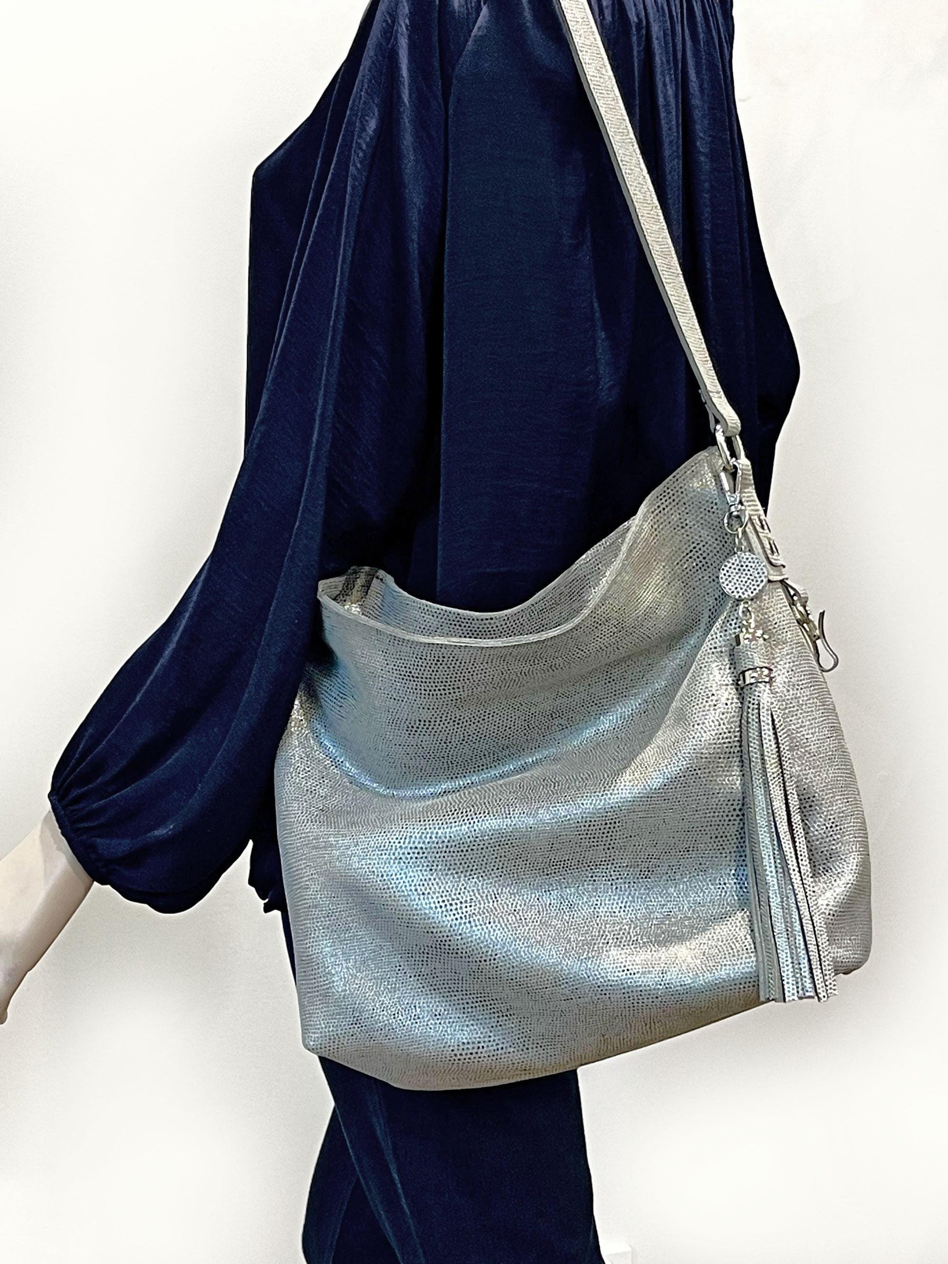 Silver handbag with a tassel charm on model