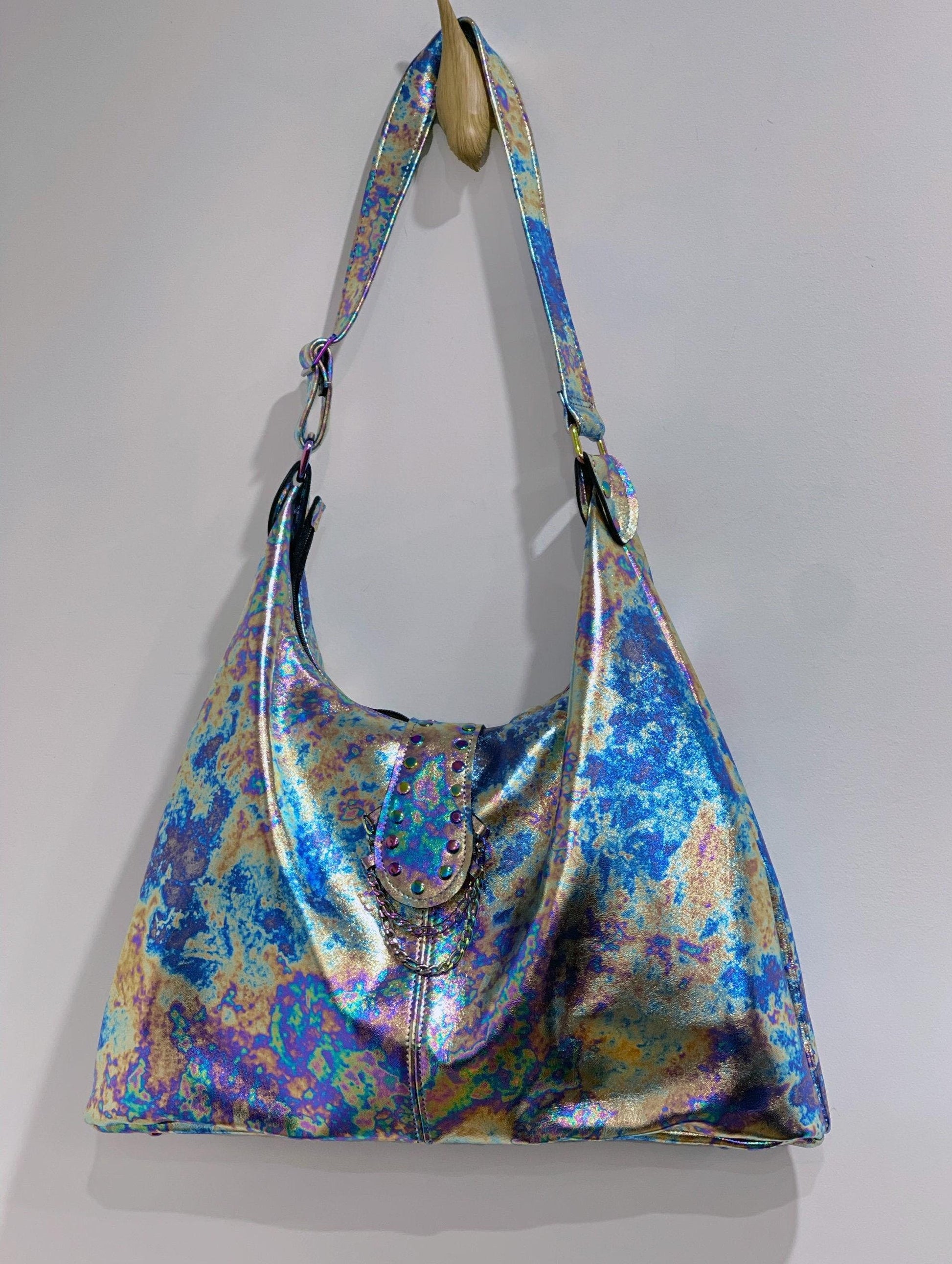 Multicolored random-patterned metallic leather handbag with rainbow hardware and chain and rivet front feature.