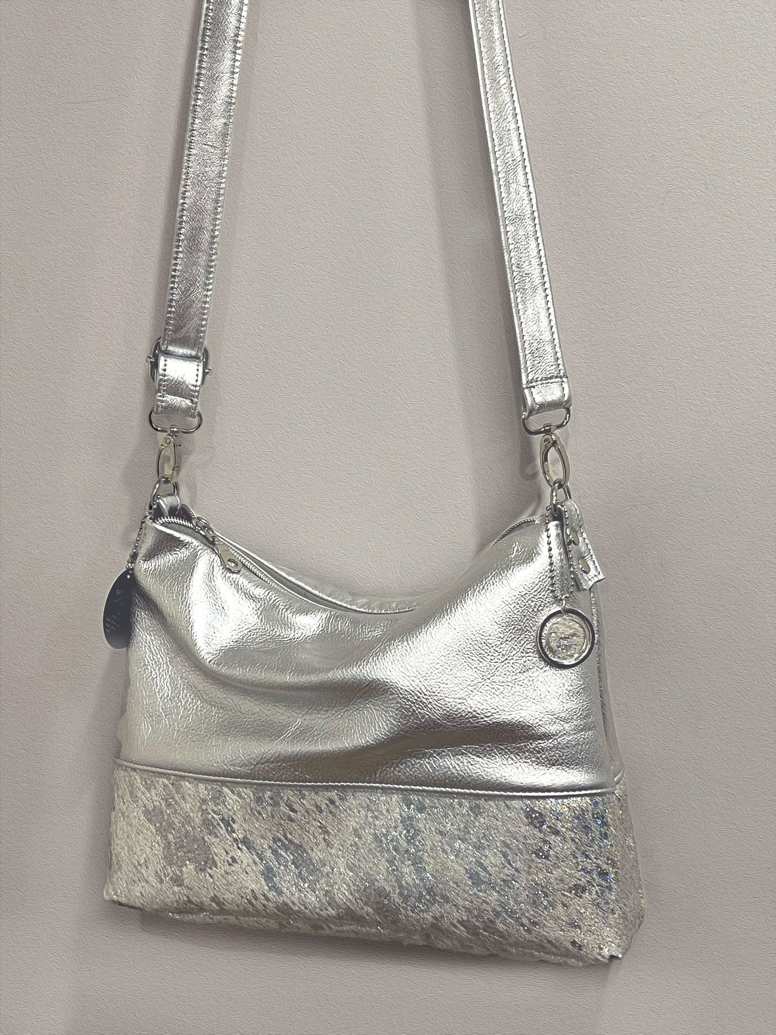 Silver handbag with a short hair iridescent base.  bag charm and removeable leather strap