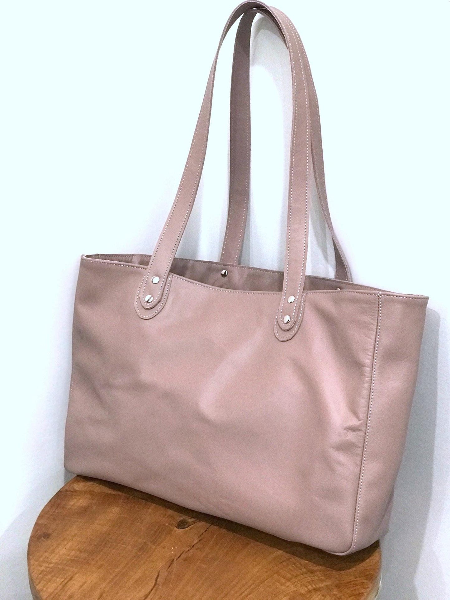 baby pink tote bag with silver hardware sits firmly without support