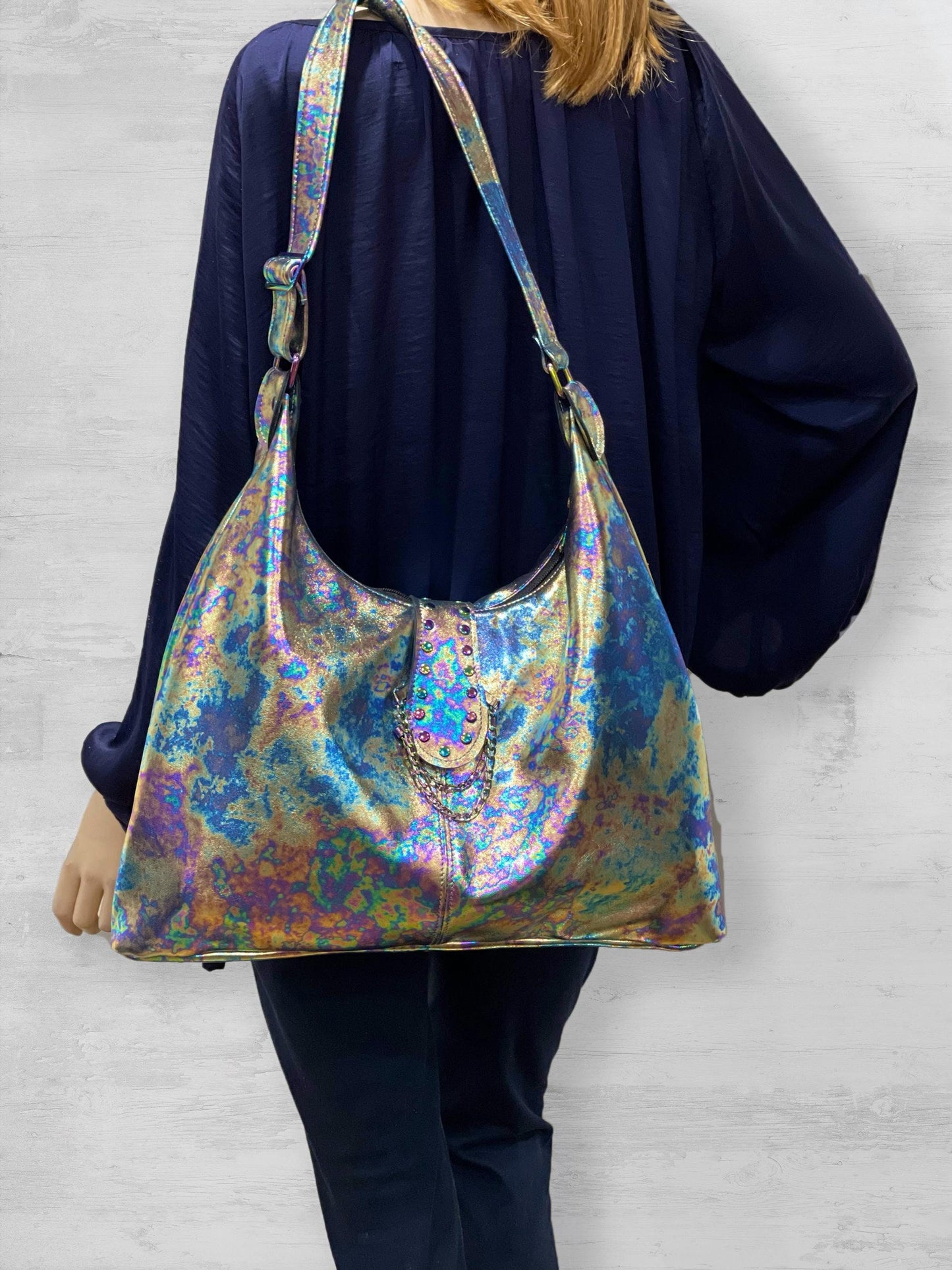 Person wearing a colorful oil slick hobo bag on shoulder