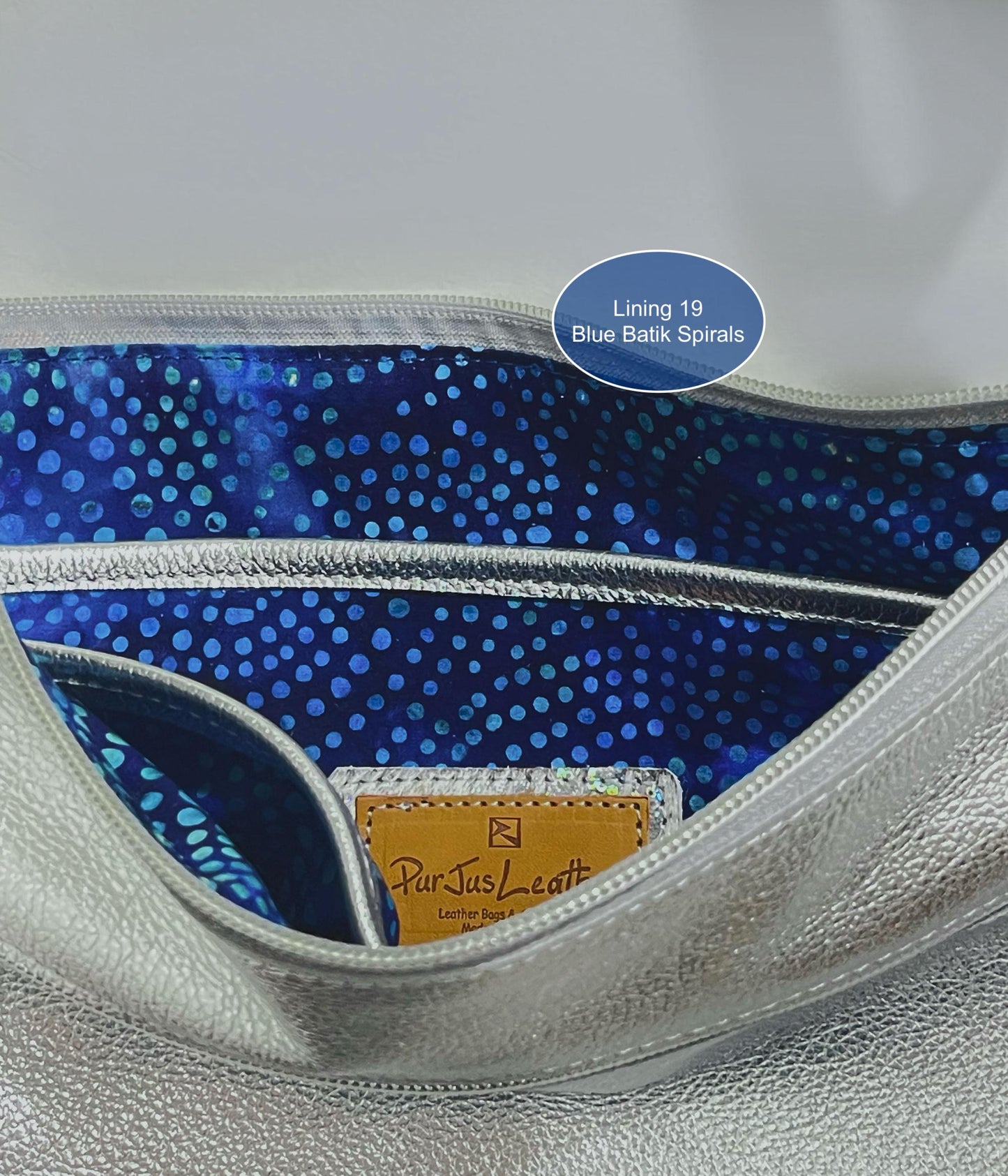 Close-up of a handbag interior with blue batik spirals lining and ParJus Craft logo.