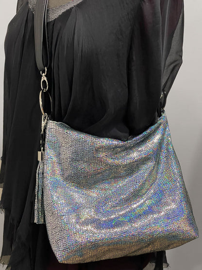Silver glittery handbag on a model with detachable black strap o large rings