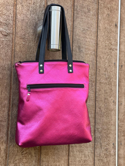 Hot Pink metallic leather tote bag with black handles and zippers with removable backpack straps