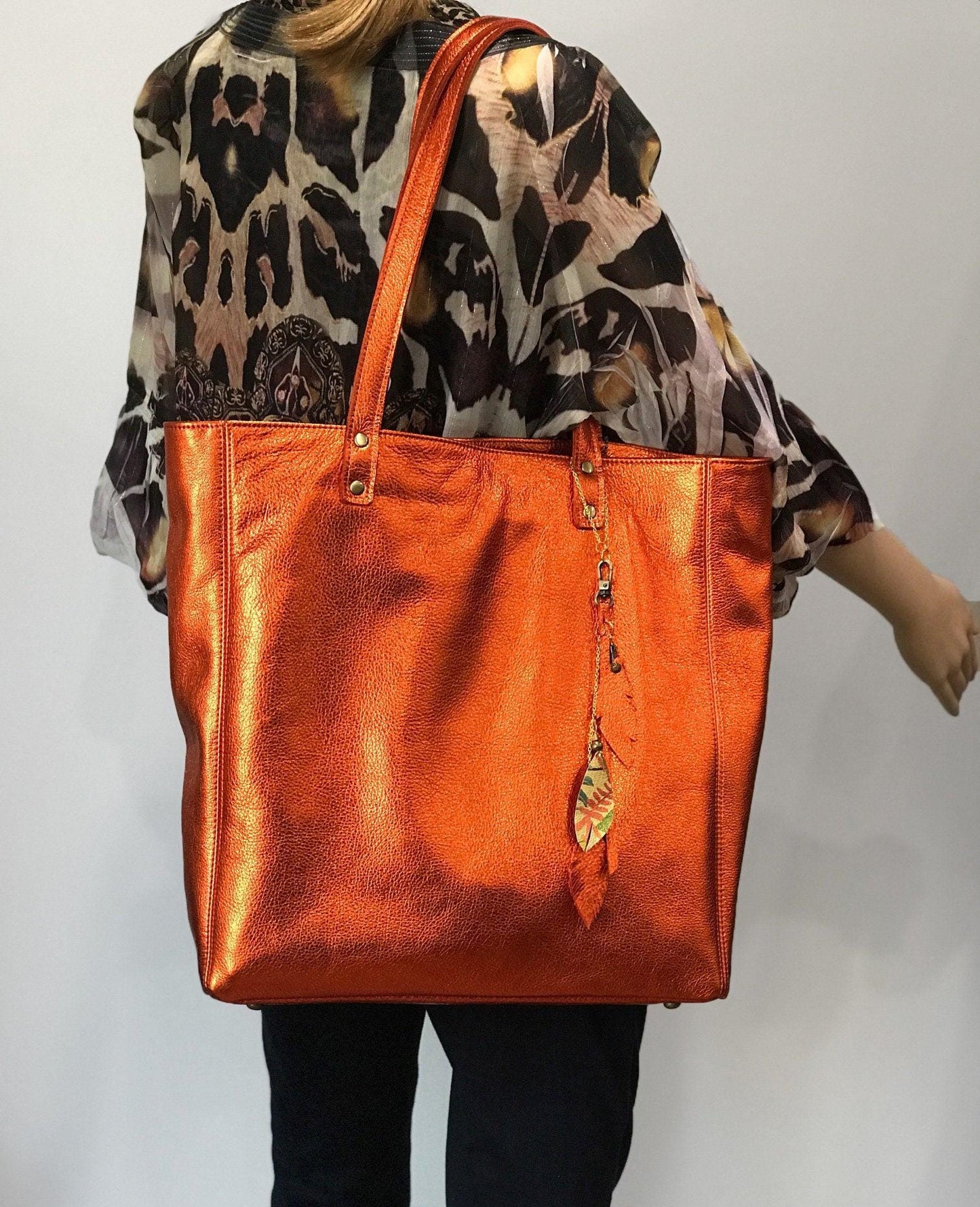 Soft warm metallic orange leather Tote lined. bottom feet and padding. Large size on model