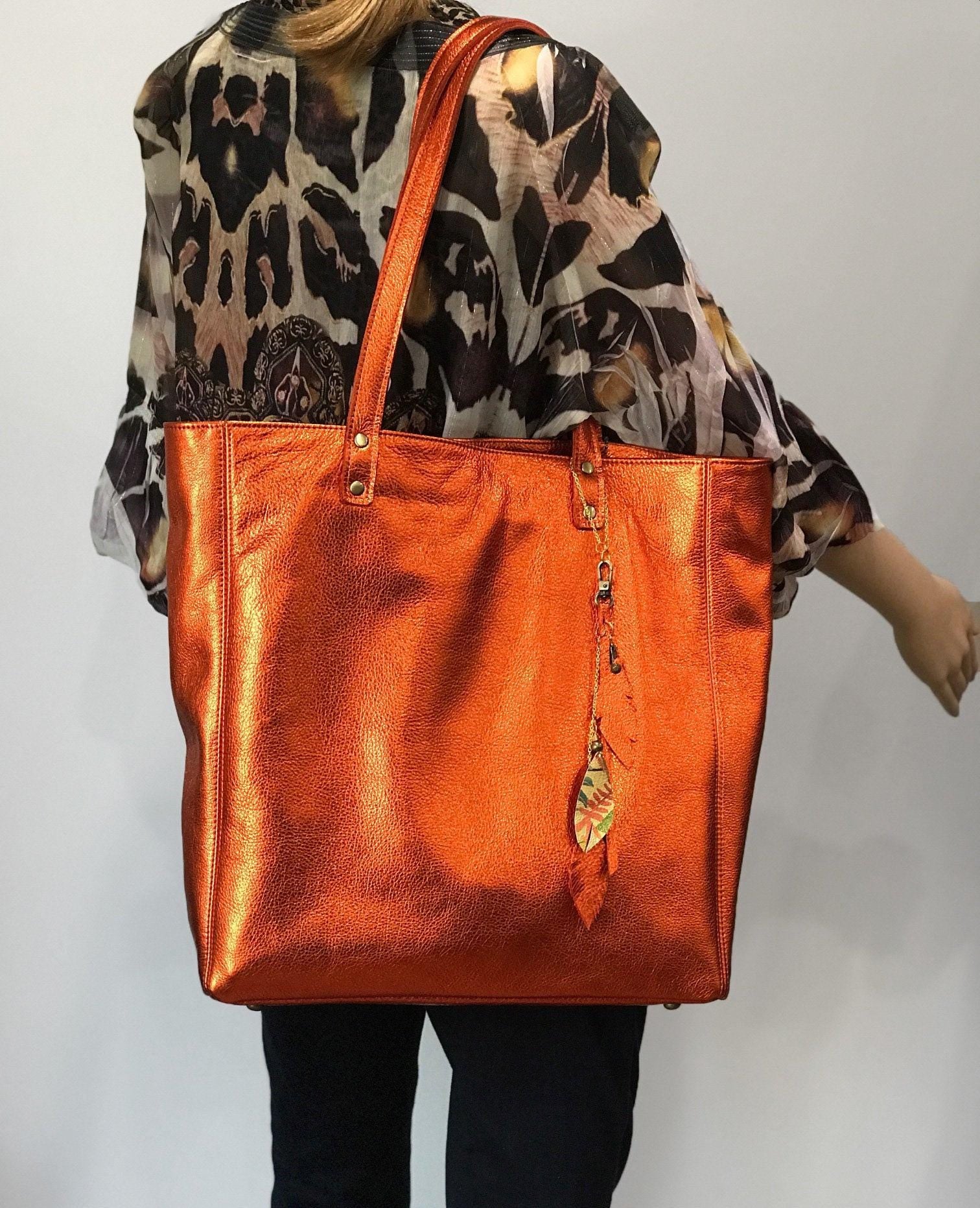 Soft warm metallic orange leather Tote lined. bottom feet and padding. Large size on model