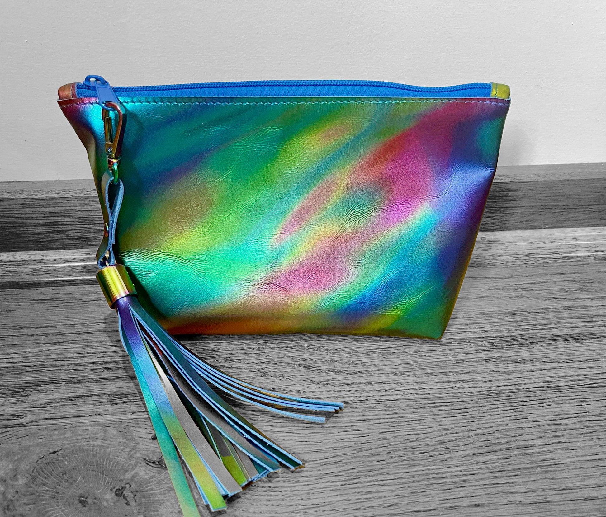Multicolored aurora style pouch with tassels on a wooden surface