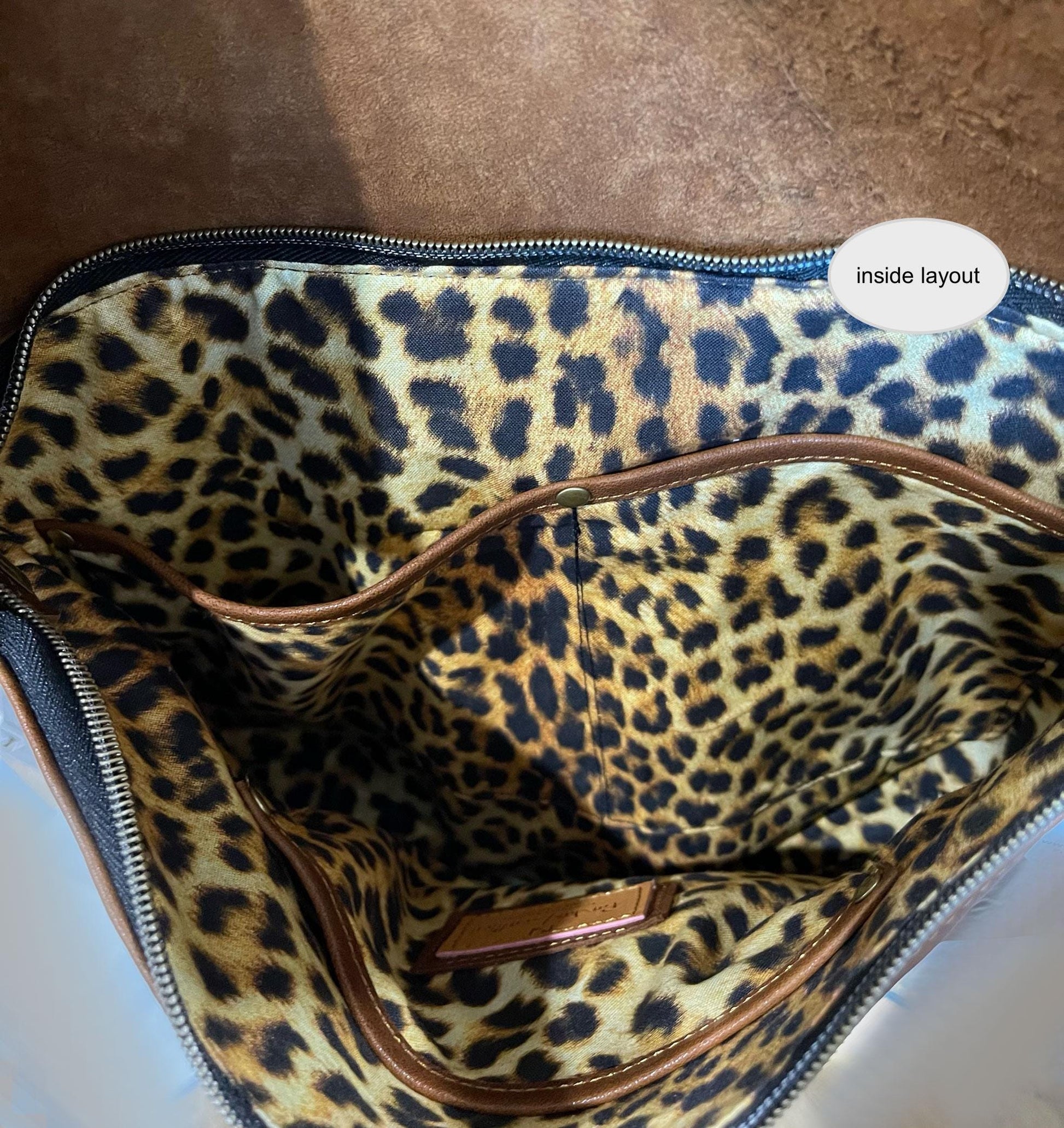 Leopard print bag interior with visible brand logo on a brown surface