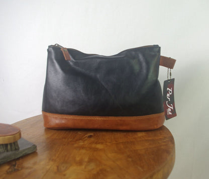 Black and brown handbag on a wooden surface with a visible tag.