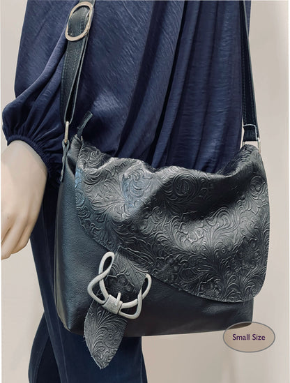 black textured handbag with decorative buckle on a plain background