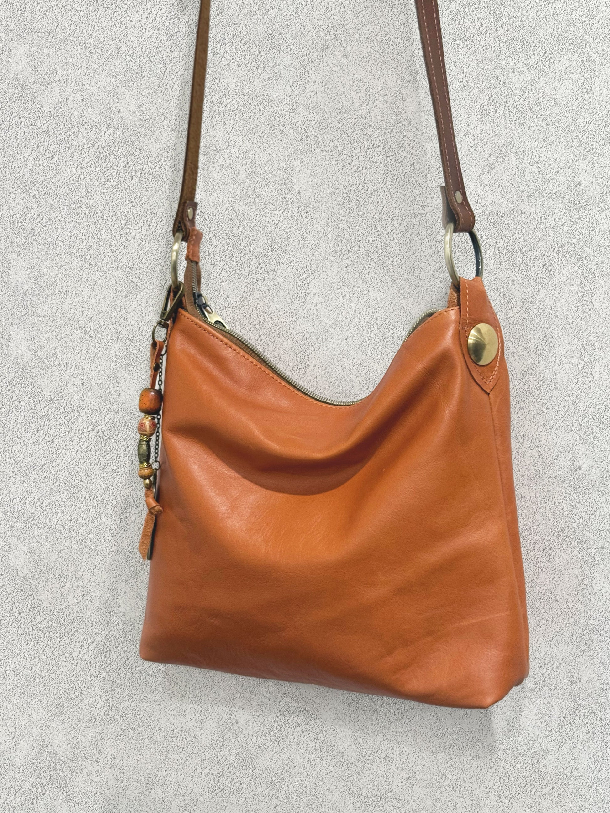 burnt orange tan leather bag with oversize brass stud