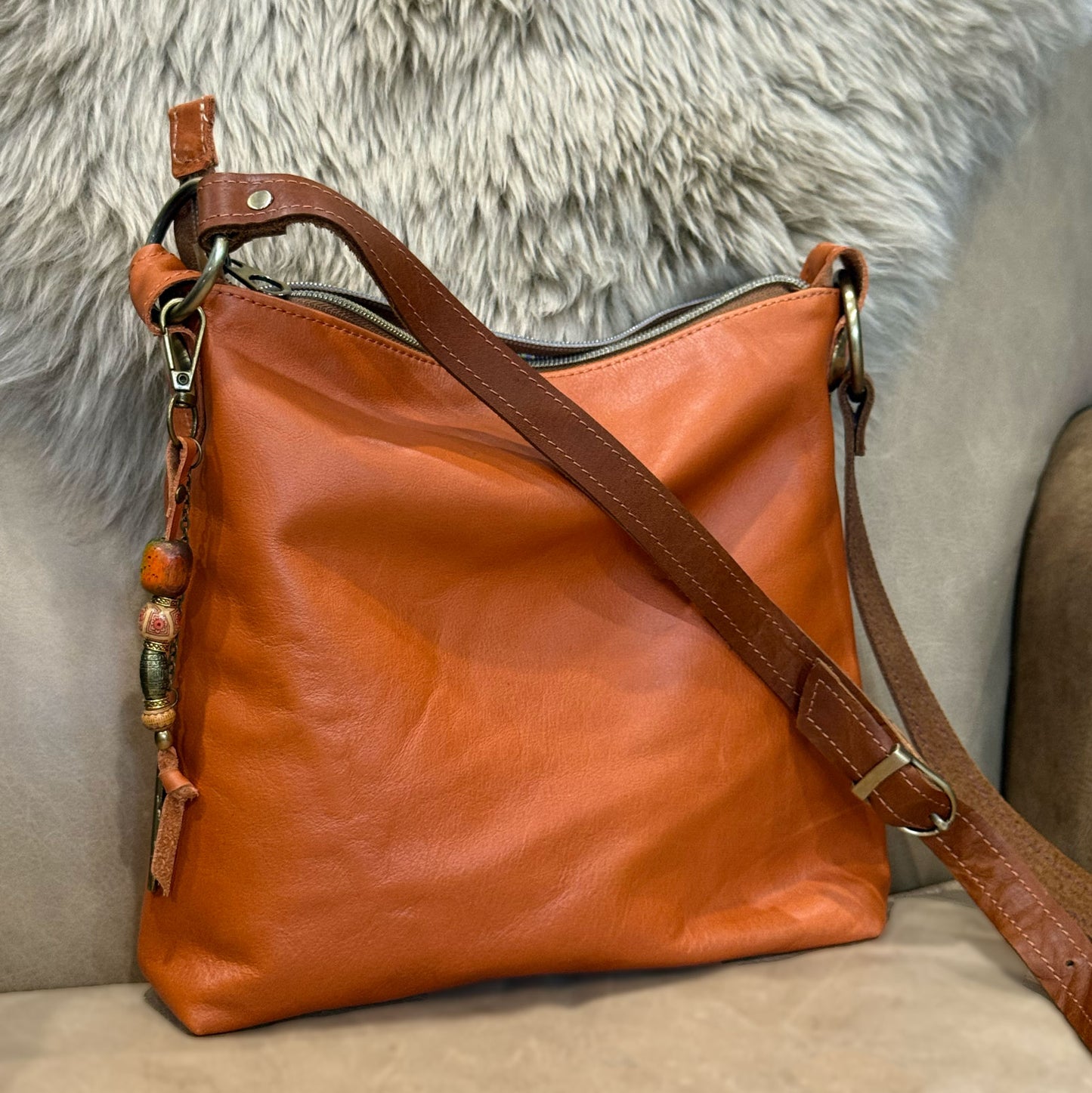 burnt orange soft leather with bead bag charm and brown crossbody strap