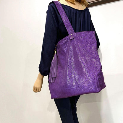 Person wearing a purple textured tote bag against plain background. double tassel custom order. double rivet straps