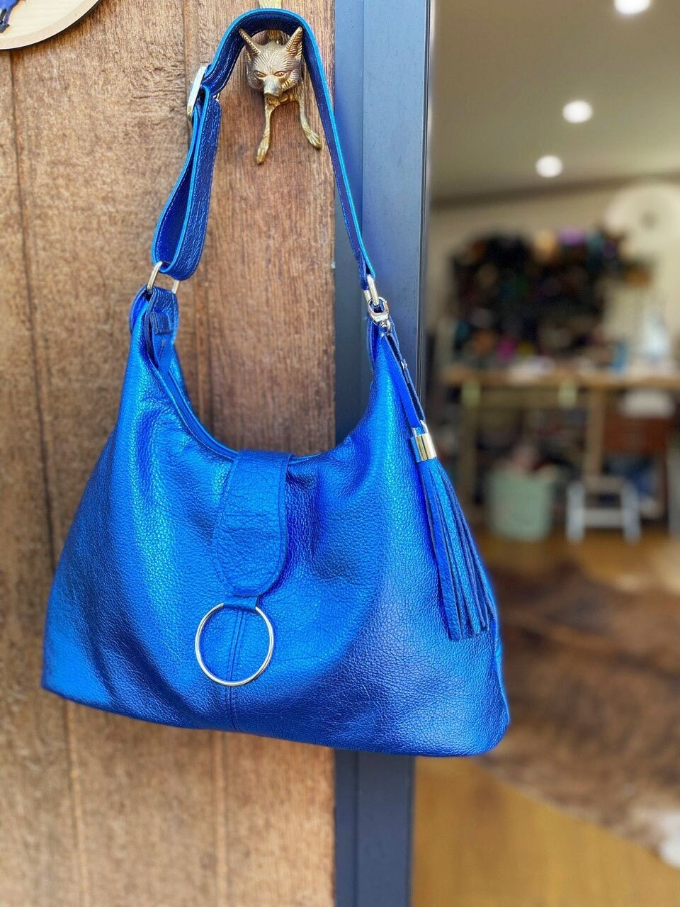 Blue handbag hanging on a wooden door