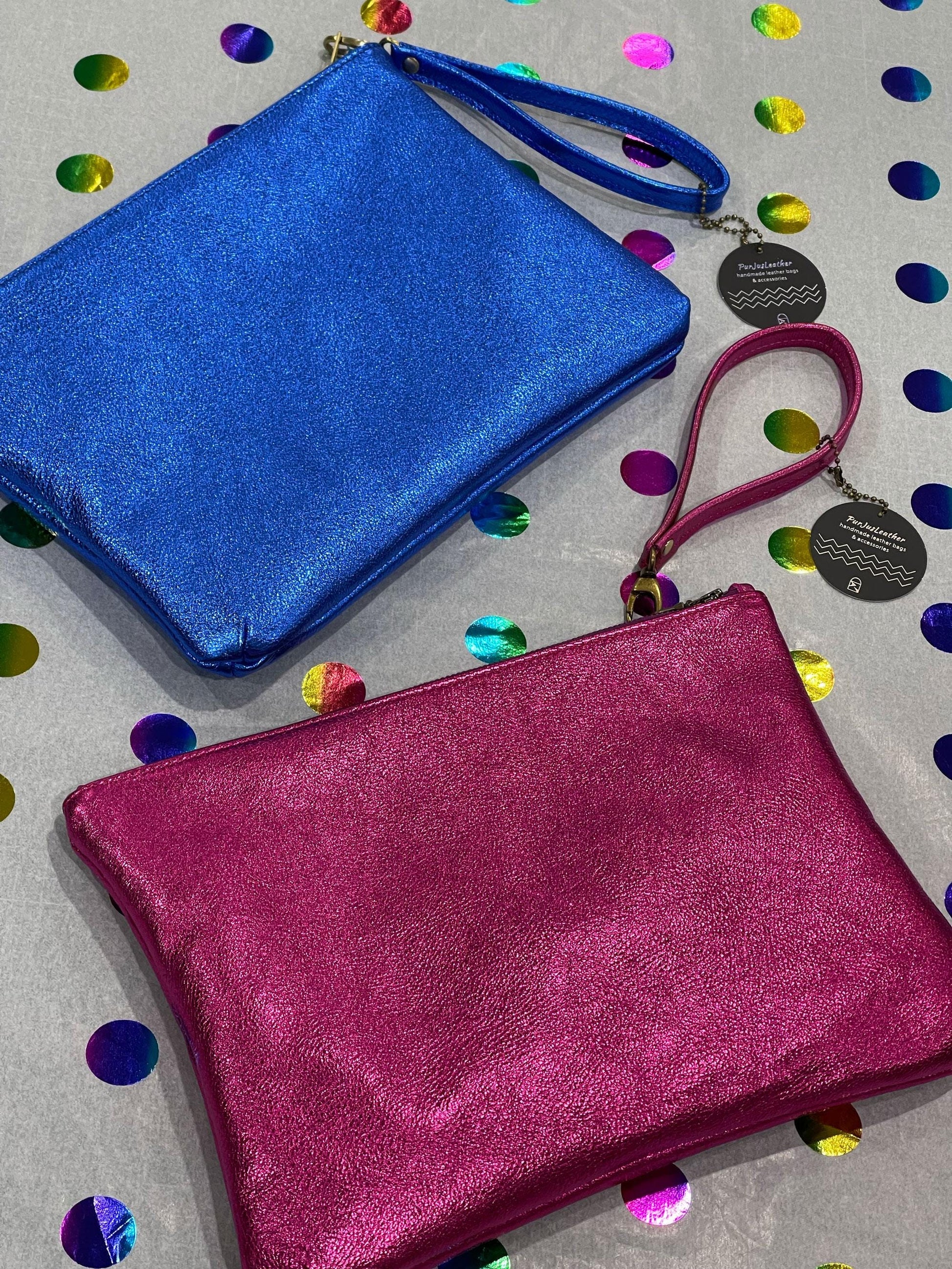 Blue and a pink clutch wristlet bag on a colorful confetti paper board.