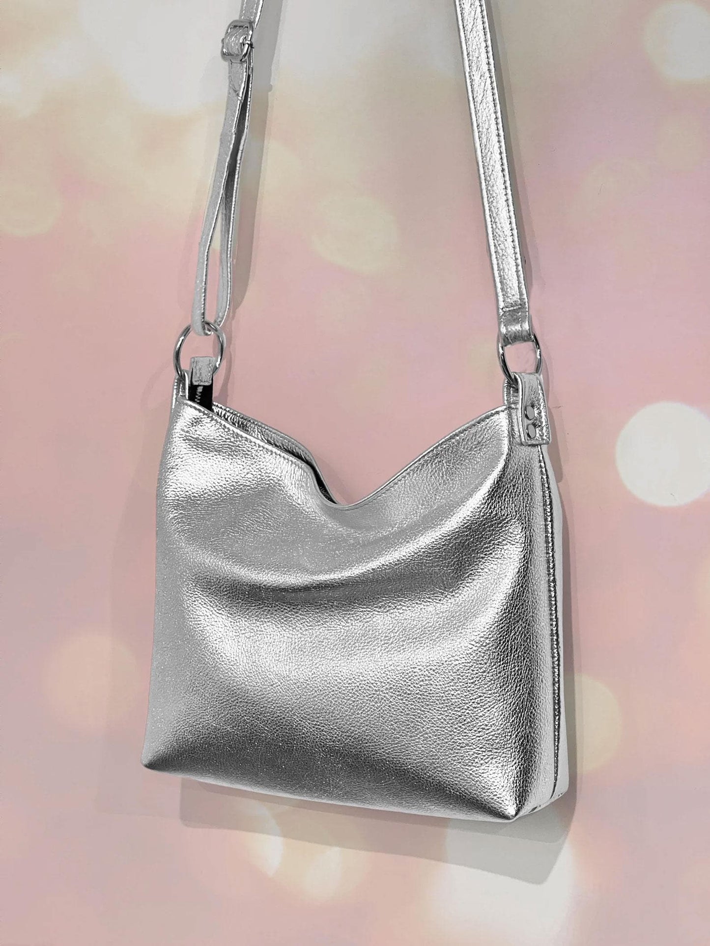 Premium Silver metallic crossbody bag with hidden zipper closure and adjustable strap attached to large O rings