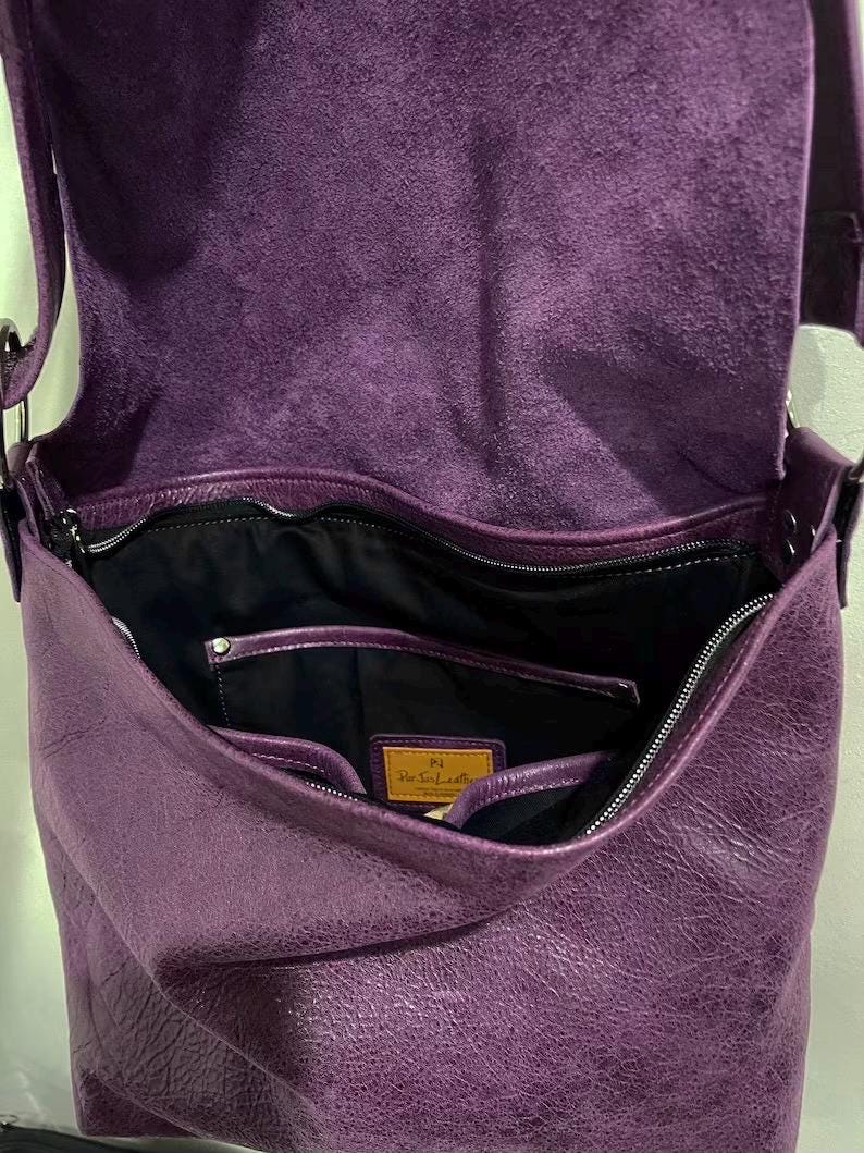 inside a distressed Purple leather bag with visible 3 slip pockets label on a light gray background