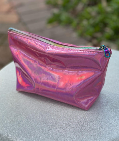 Holographic pink pouch outside with sun reflection and rainbow zipper closure