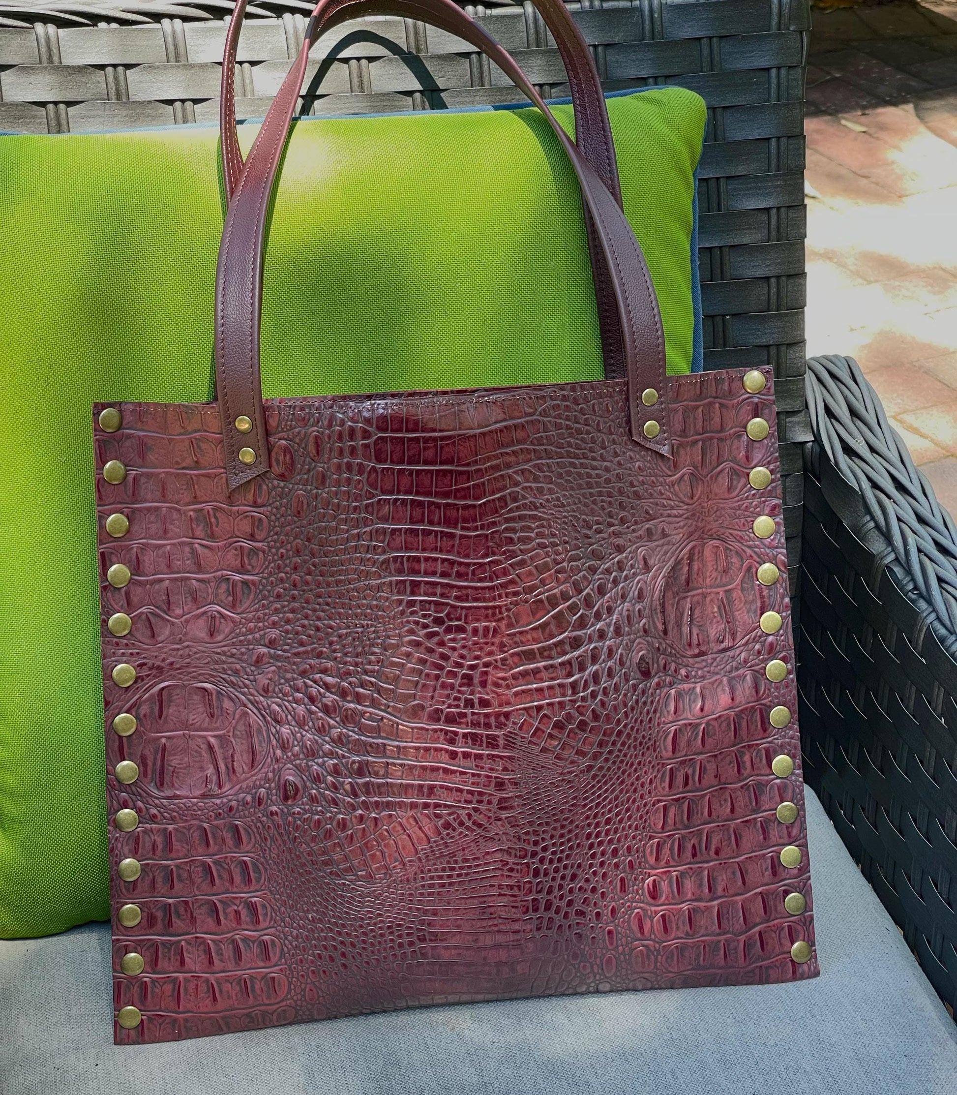 burgundy crocodile textured tote bag with brass studs and strong double handles