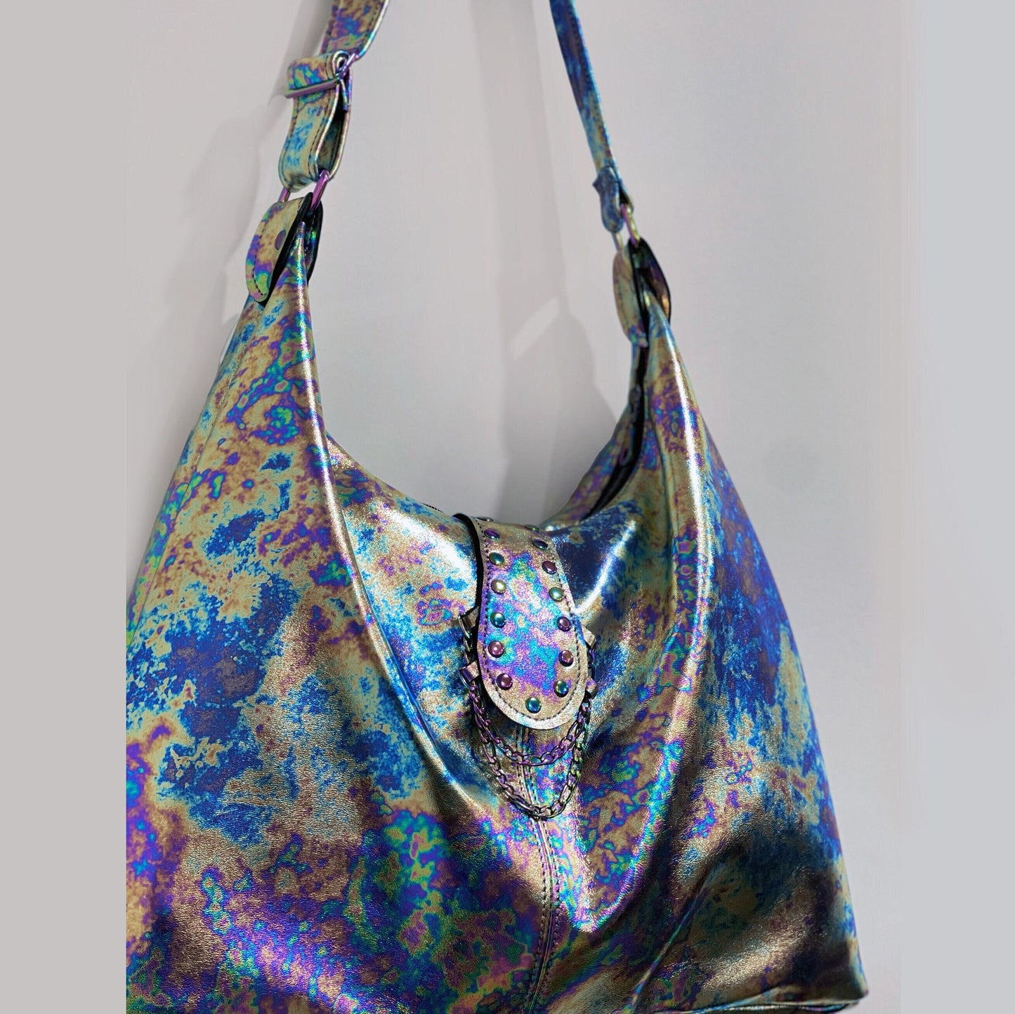 close up of tie dye leather handbag with decorative studs and chain