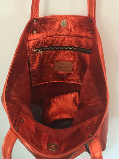Inside warm orange tote with zipper pocket and free zipper purse. brass hardware. magnet closure