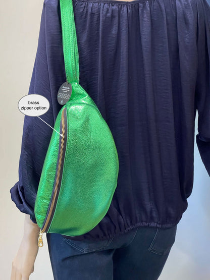 Green metallic bag with brass zipper option on a plain background