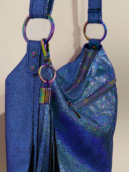 Close up of Blue metallic iridescent bag with a strap and decorative rings 