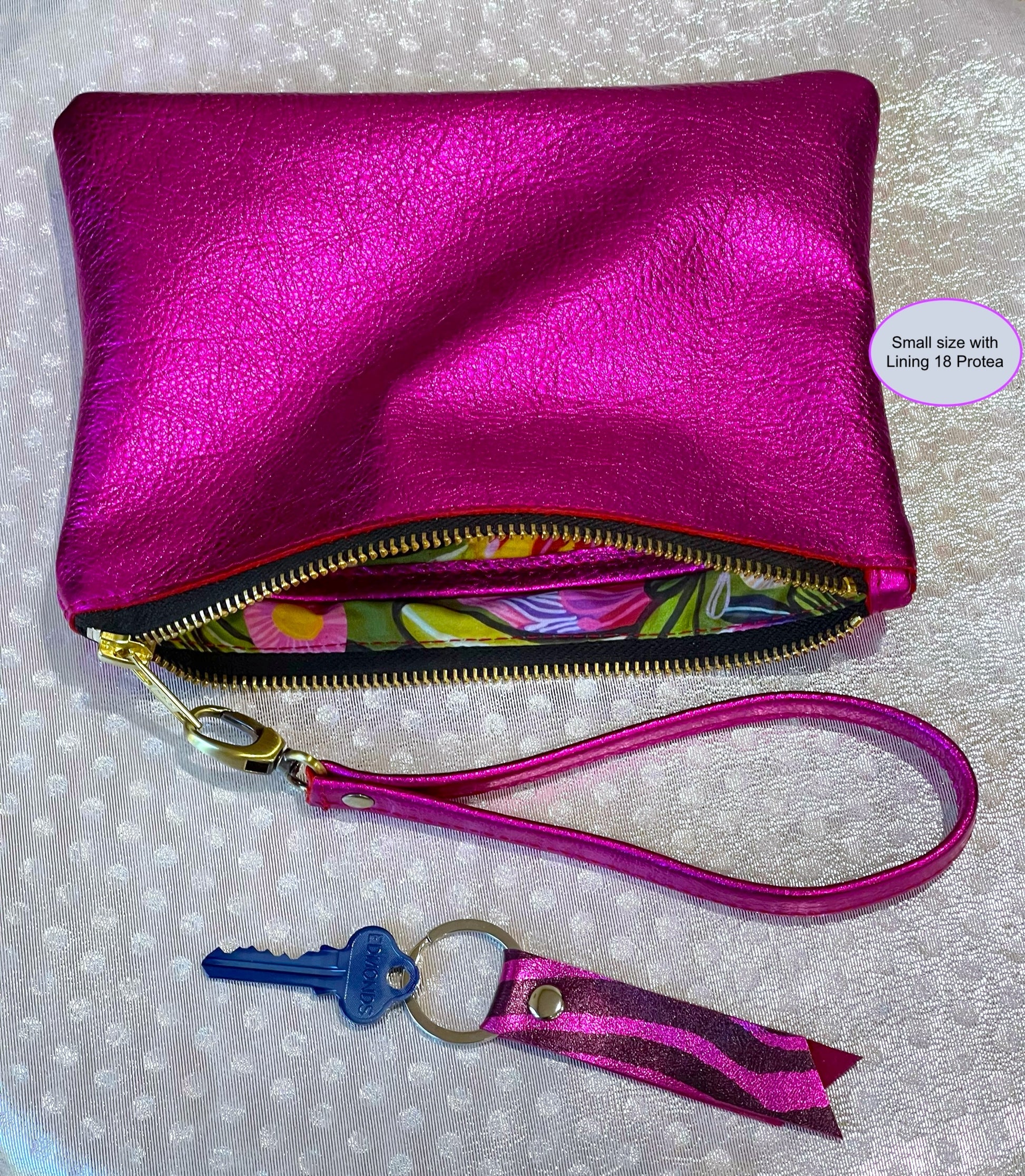 fuchsia Pink clutch with floral lining interior, keychain, and detachable wristlet strap