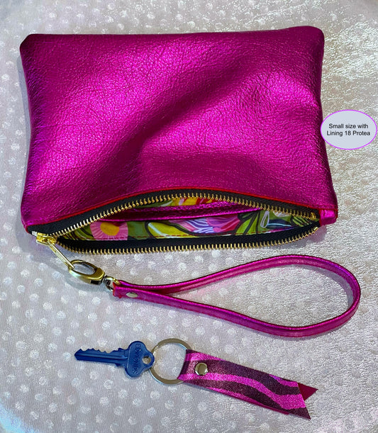 fuchsia Pink clutch with floral lining interior, keychain, and detachable wristlet strap