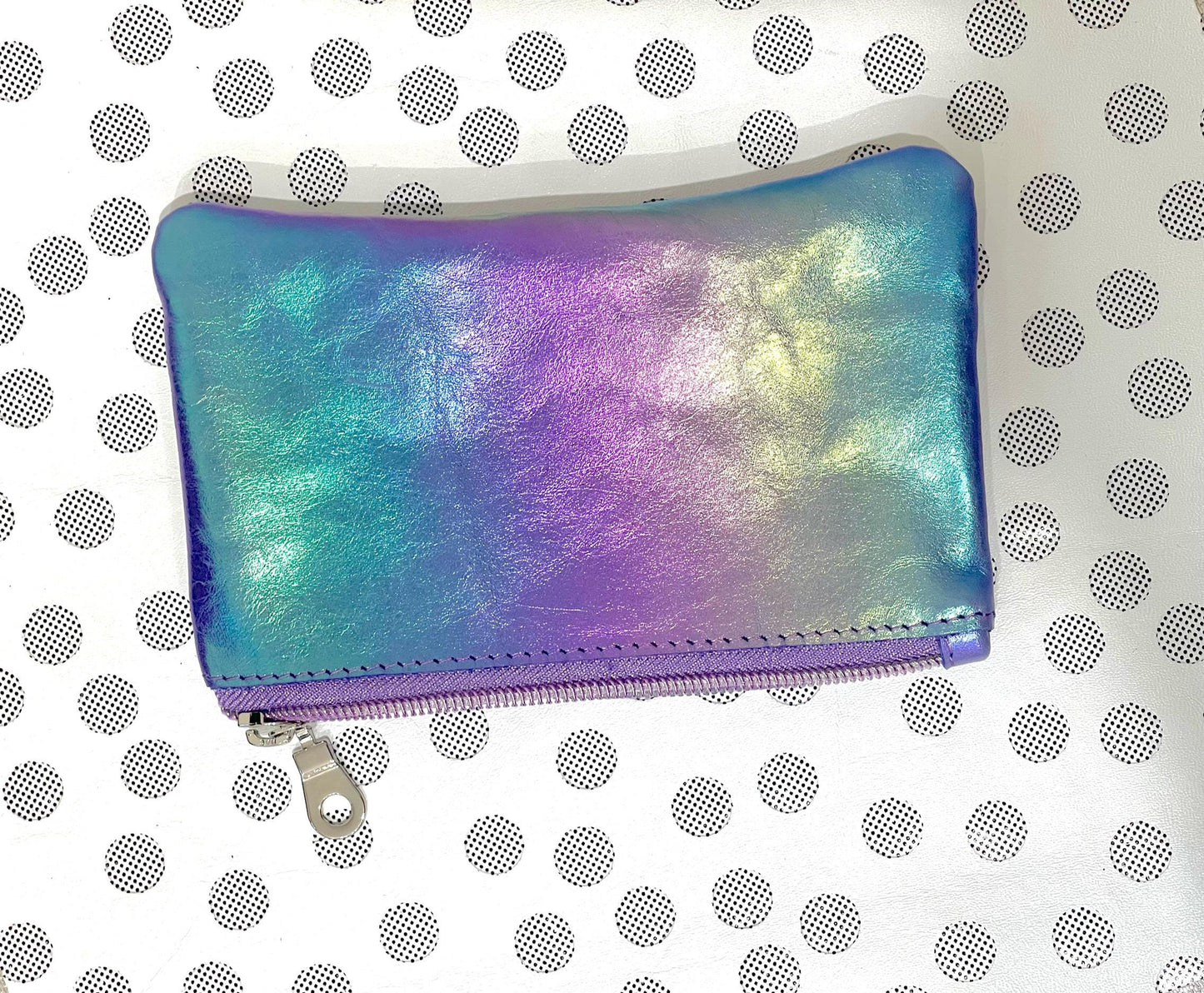 Iridescent coin purse on a white background with black polka dots