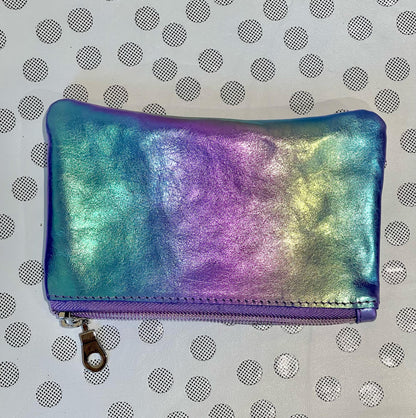 Iridescent rainbow pouch with a zipper on a polka dot background