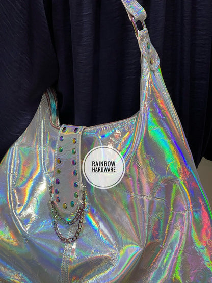 close up of Holographic handbag with 'Rainbow Hardware' and unique rivet chain feature on a dark background