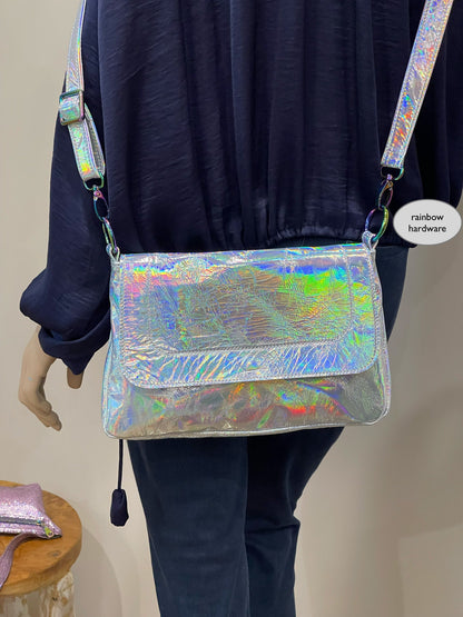 Person wearing a reflective silver crossbody bag with colorful hardware.