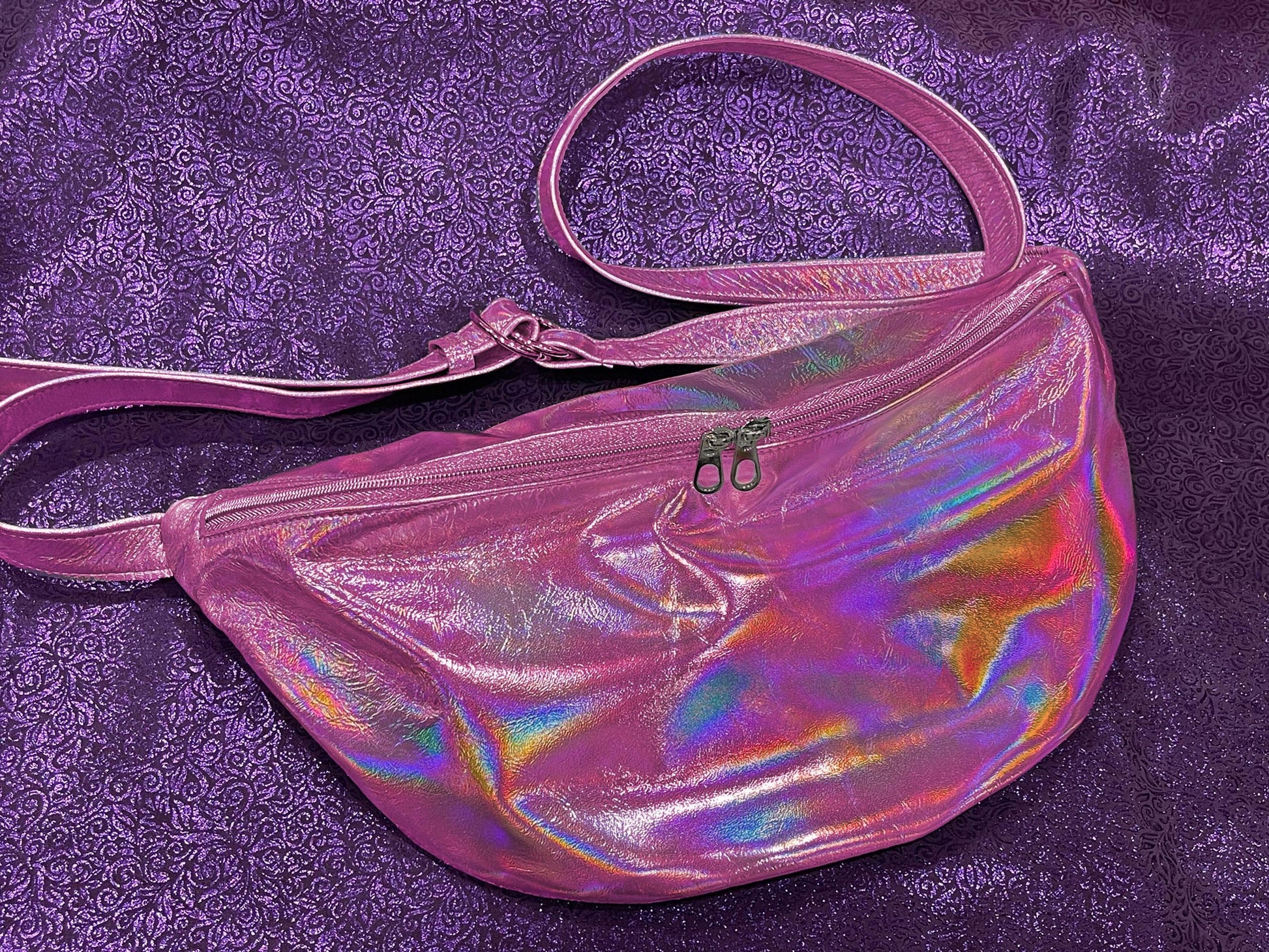 Holographic pink waist sling bag with metallic pink zipper and 2 zipper pulls for easy access