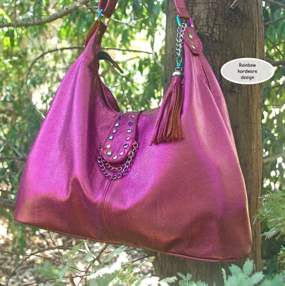 metallic hot pink hobo handbag with rainbow hardware and tassel on a chain hanging on a tree branch