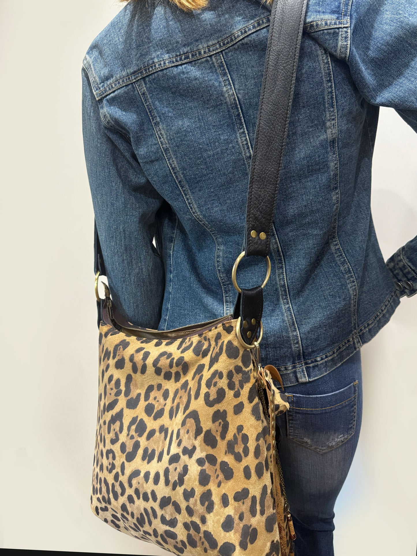 Person wearing a leopard print bag with a plain background
