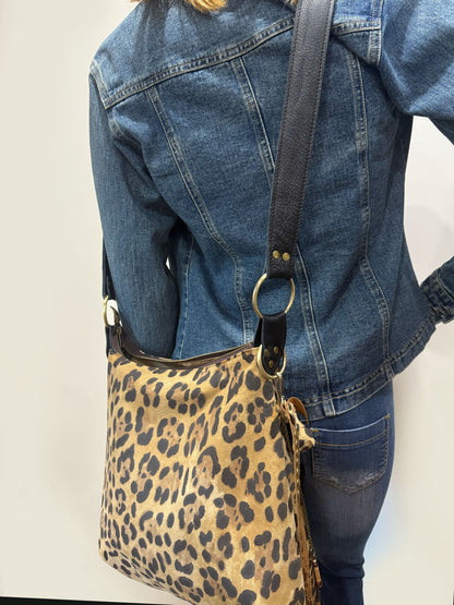 Person wearing a leopard print bag with a plain background