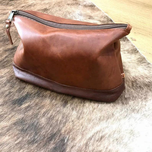 A brown leather toiletry bag with a zipper, perfect for all men