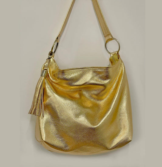 Gold metallic handbag scrunched to show how soft and pliable the leather is. Large O rings hold strap