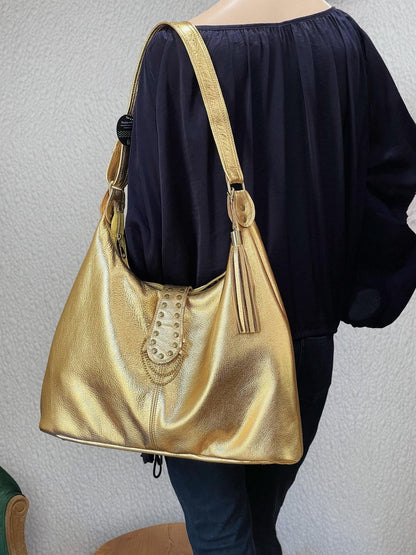 Gold metallic leather handbag brass stud feature. leather tassel and brass hardware. foam bottom to protect laptop