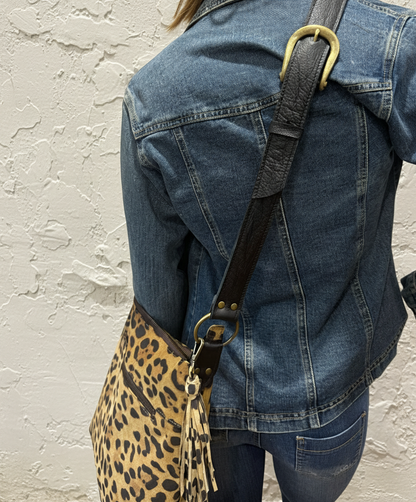 Model with leopard bag on rustic off-white wall