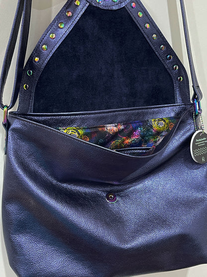 Navy blue leather handbag with colorful interior lining and decorative studs.