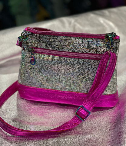 Handbag with pink strap and trim on a textured surface