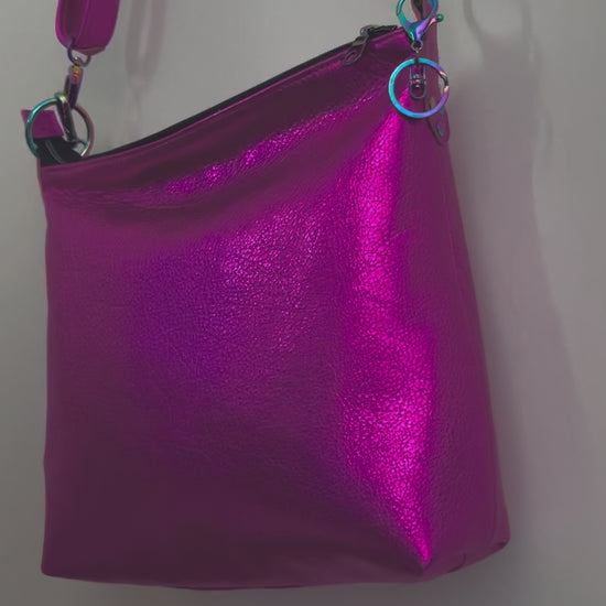 moving image of hot pink leather bag opening the bag and showing pockets and outside the bag zipper pocket and metal charm