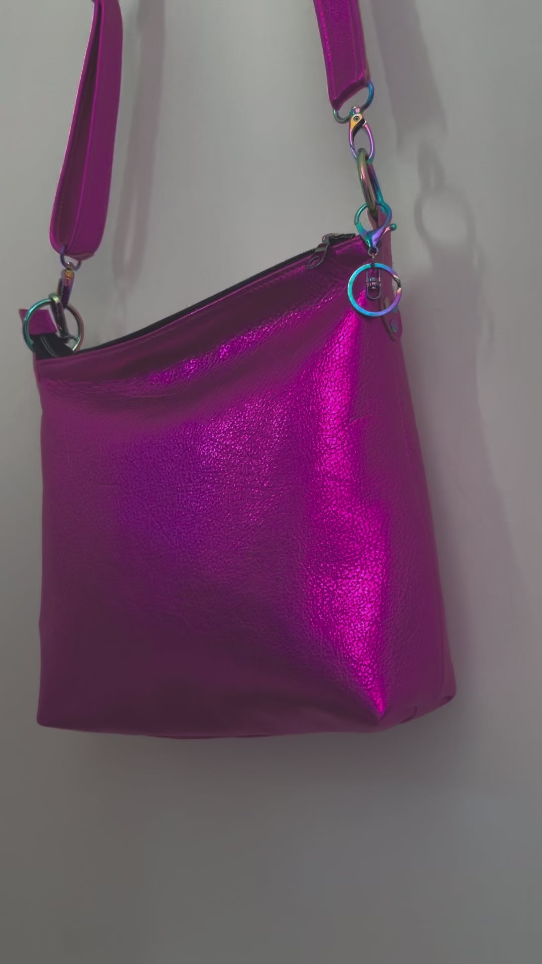 moving image of hot pink leather bag opening the bag and showing pockets and outside the bag zipper pocket and metal charm