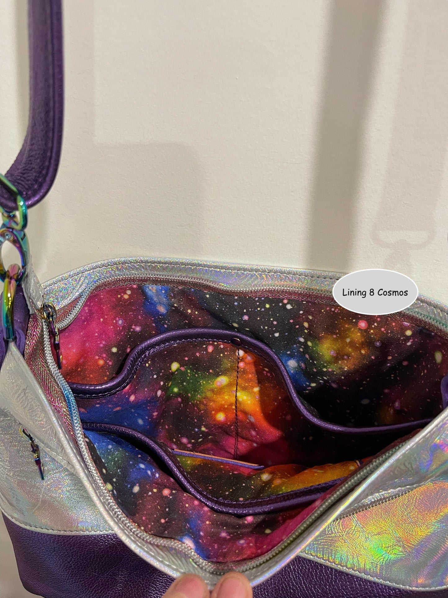Colorful galaxy-theme lining inside bag with a visible brand label and 3 easy access slip pockets and zipper closure