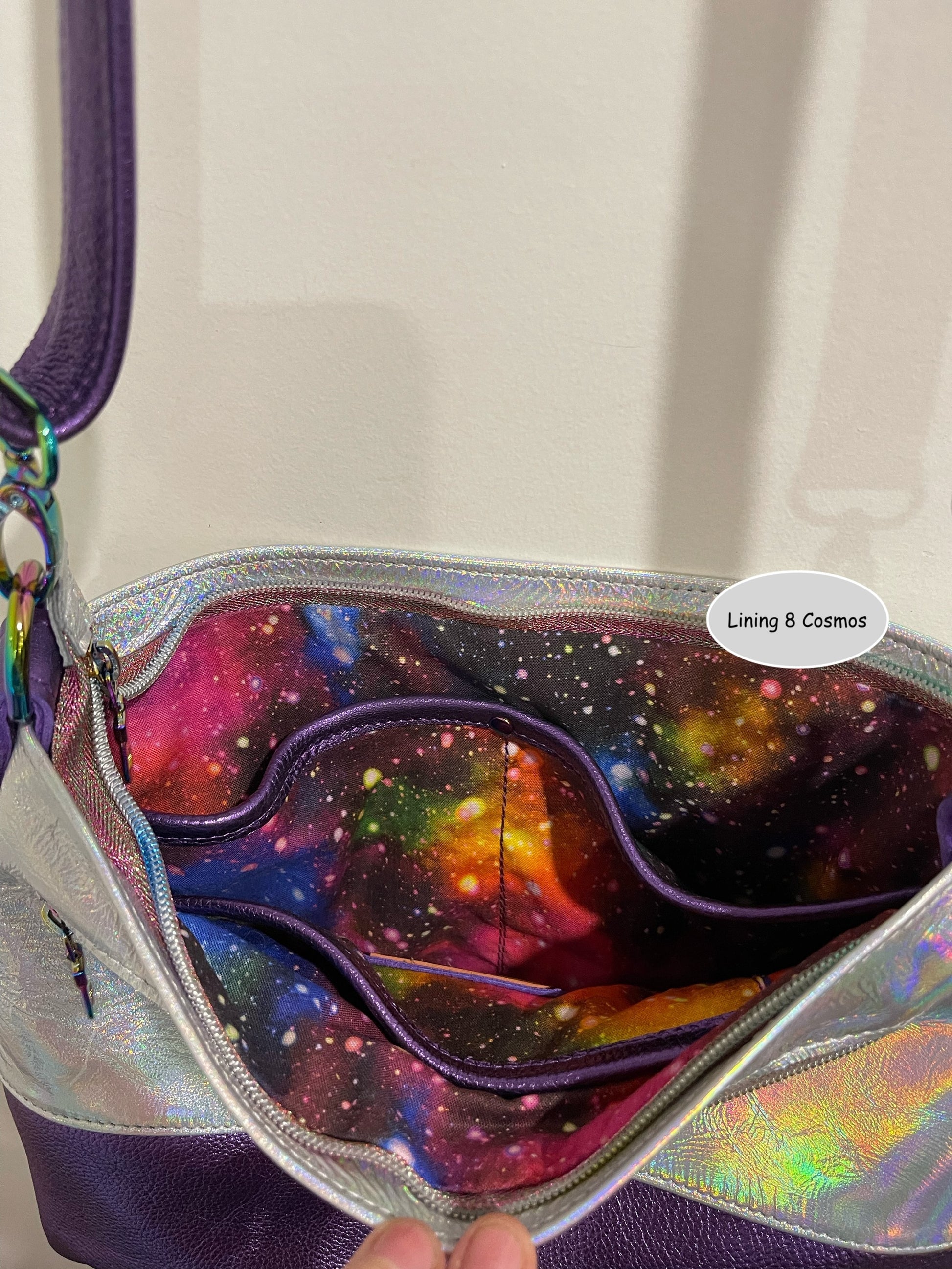 Colorful galaxy-theme lining inside bag with a visible brand label and 3 easy access slip pockets and zipper closure